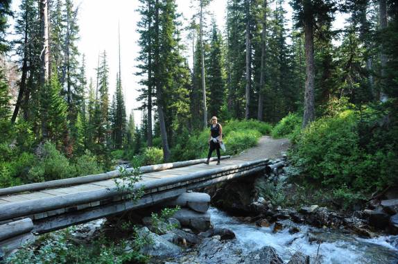 Atravessando riacho na trilha pelo canyon Paintbrush, no Grand Teton National Park, no Wyoming, nos Estados Unidos